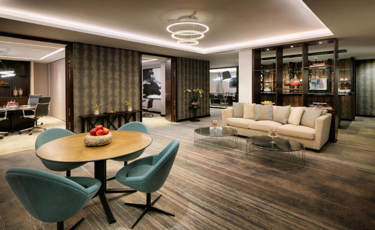 ein Wohnzimmer mit einer Couch und einem Tisch und Stühlen in der Unterkunft Hyatt Regency Köln in Köln ein Wohnzimmer mit einer Couch und einem Tisch und Stühlen in der Unterkunft Hyatt Regency Köln in Köln