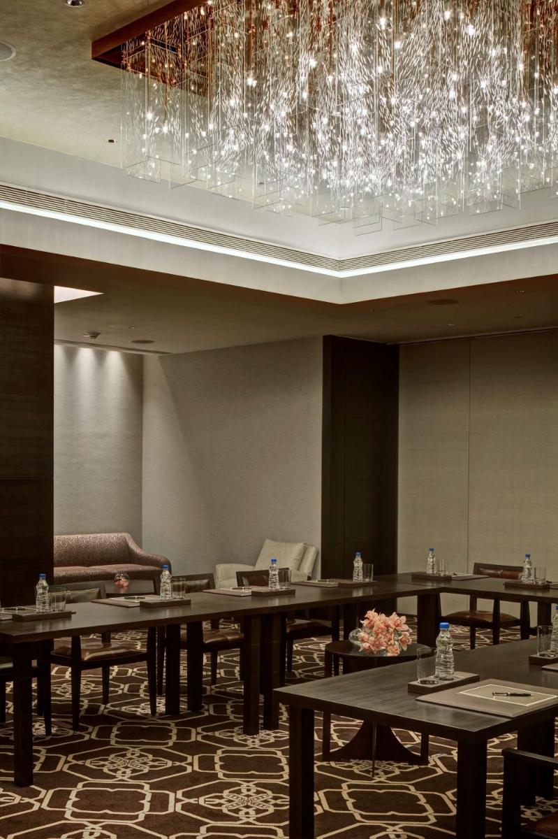 a dining room with tables and chandeliers at Park Hyatt Hotel and Residences, Hyderabad in Hyderabad
