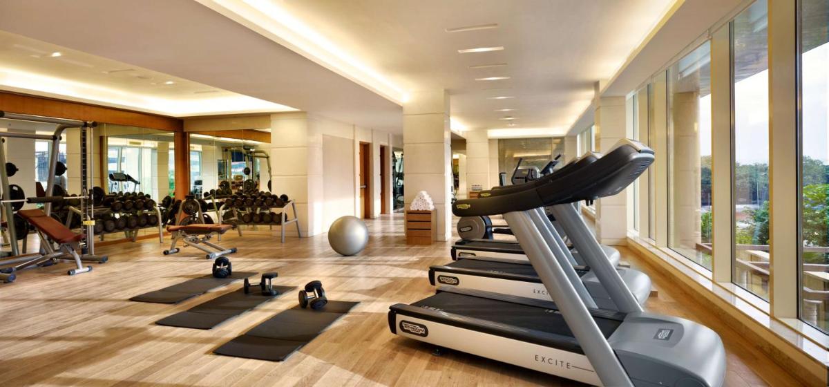 a gym with a treadmill and other exercise equipment at Hyatt Regency Pune Hotel & Residences in Pune