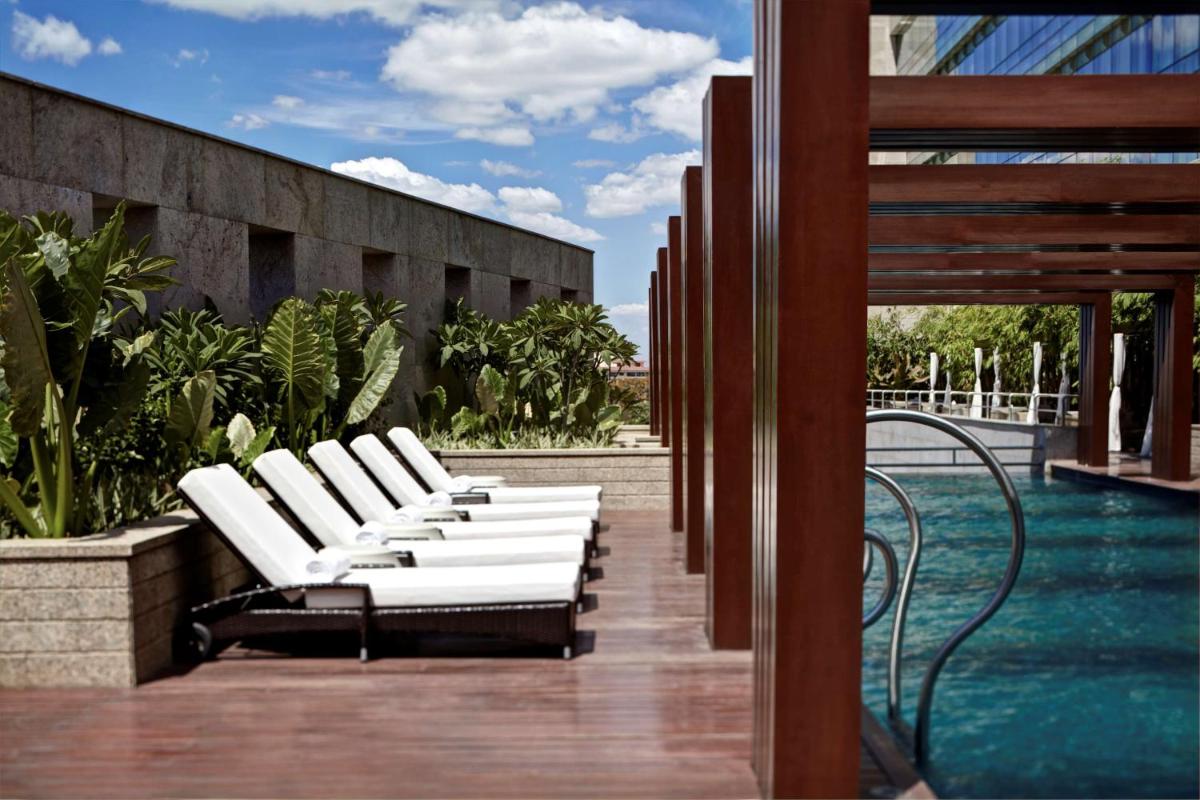 a row of white lounge chairs on a patio at Park Hyatt Hotel and Residences, Hyderabad in Hyderabad