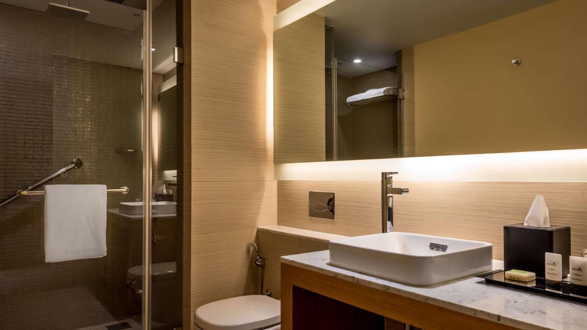a bathroom with a sink and a toilet and a mirror at Hyatt Place Pune Hinjawadi in Pune