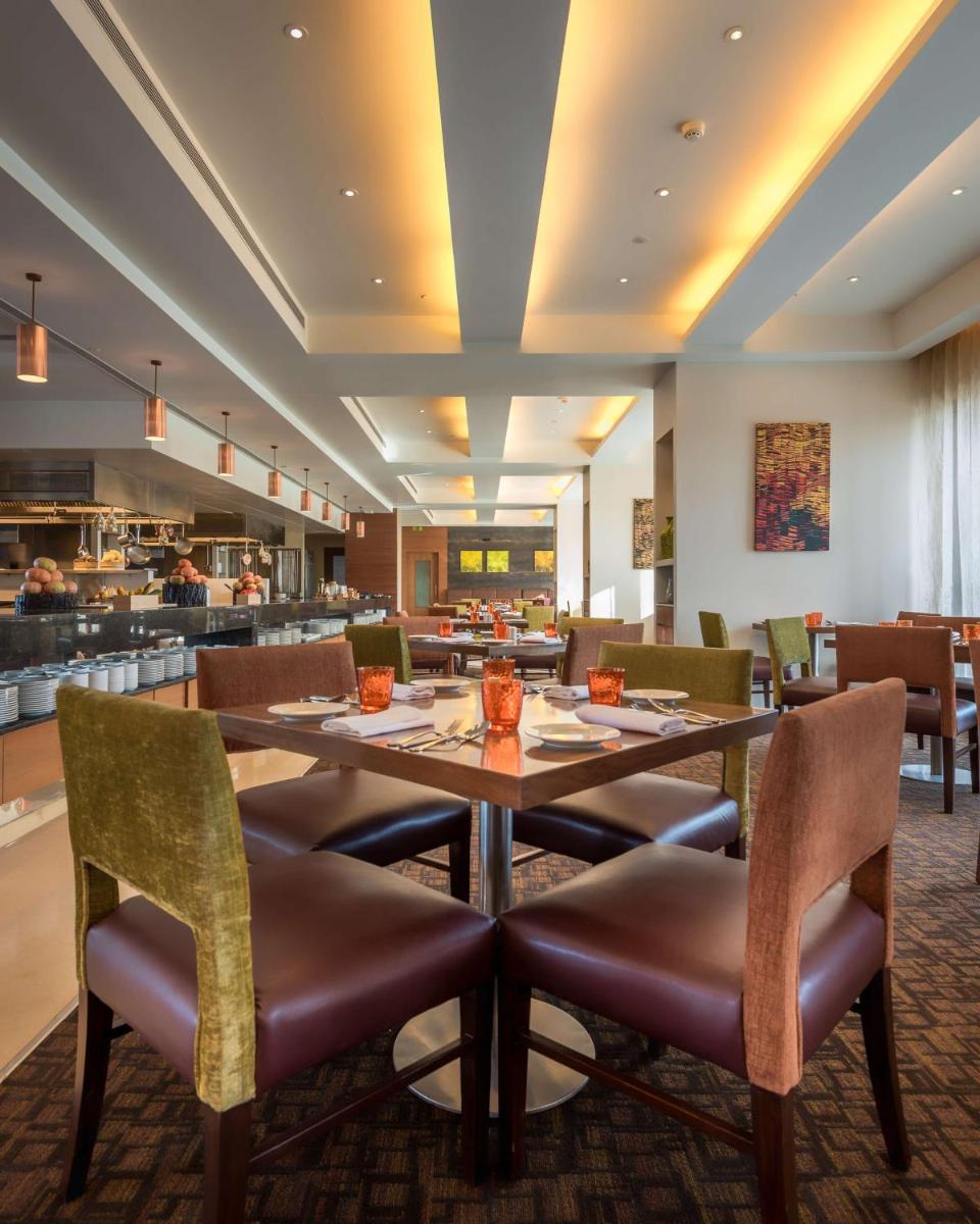 a dining room with a table and chairs at Hyatt Place Pune Hinjawadi in Pune