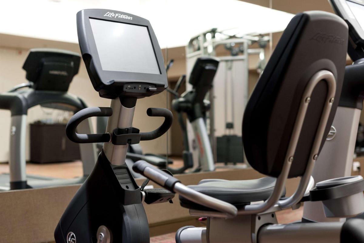 a gym with exercise bikes and a tablet on a treadmill at Hyatt Place Pune Hinjawadi in Pune