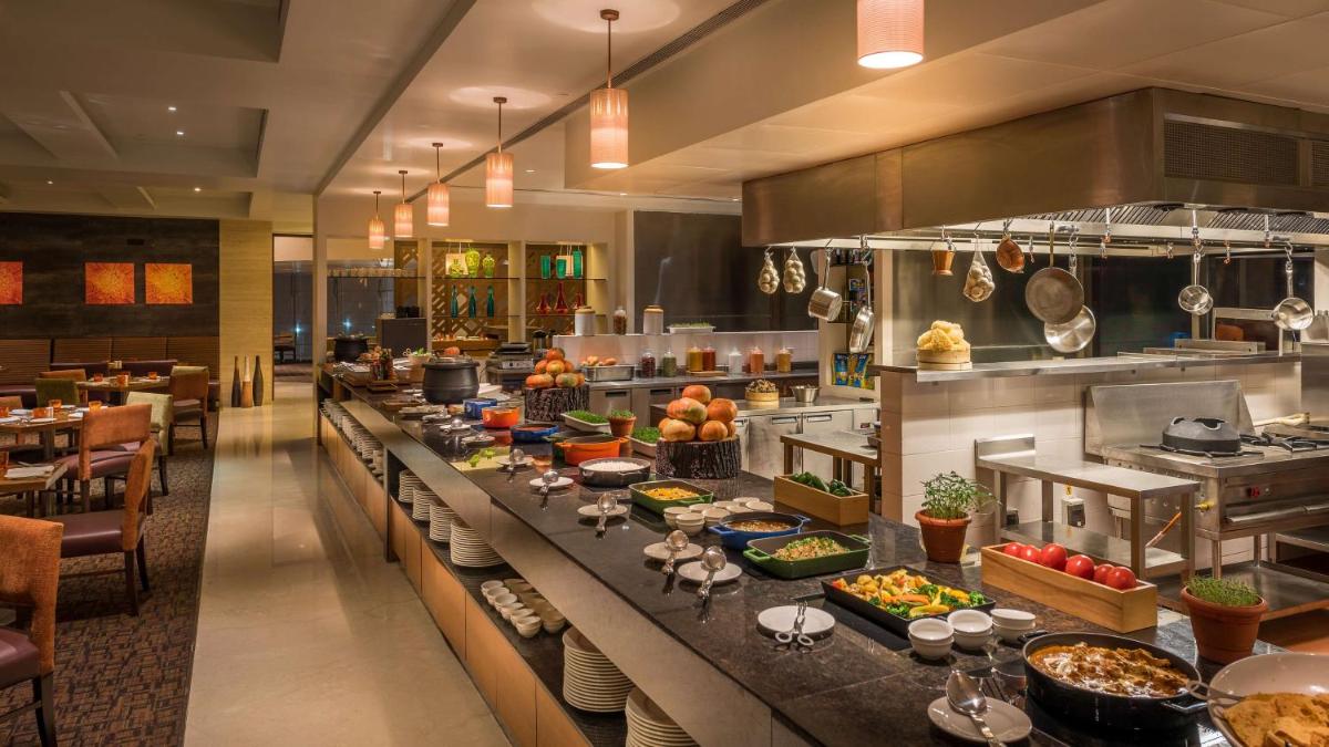 a buffet line in a restaurant with food on it at Hyatt Place Pune Hinjawadi in Pune