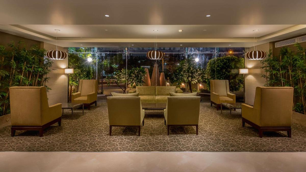 a hotel lobby with chairs and a table and a table and chairs at Hyatt Place Pune Hinjawadi in Pune