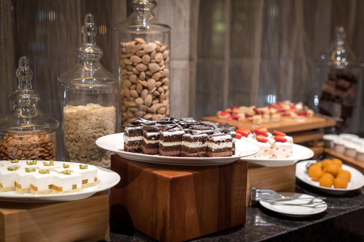a buffet with several different types of cakes and other desserts at Hyatt Place Pune Hinjawadi in Pune