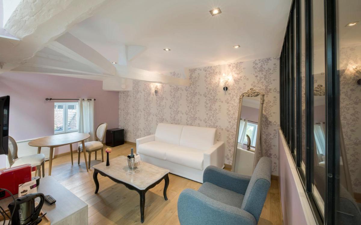 un salon avec un canapé blanc et une table dans l'établissement Logis Hôtel Restaurant Aux Maisons, à Maisons-lès-Chaource