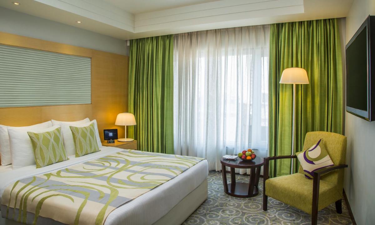 a hotel room with a bed and a chair at Radisson Blu Hotel Ahmedabad in Ahmedabad