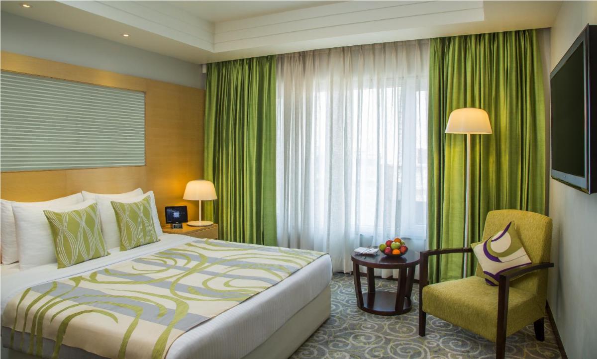 a hotel room with a bed and a chair at Radisson Blu Hotel Ahmedabad in Ahmedabad