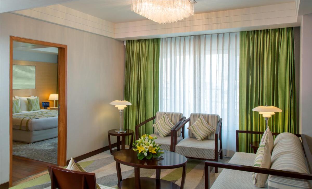 a living room with a couch and a bed at Radisson Blu Hotel Ahmedabad in Ahmedabad