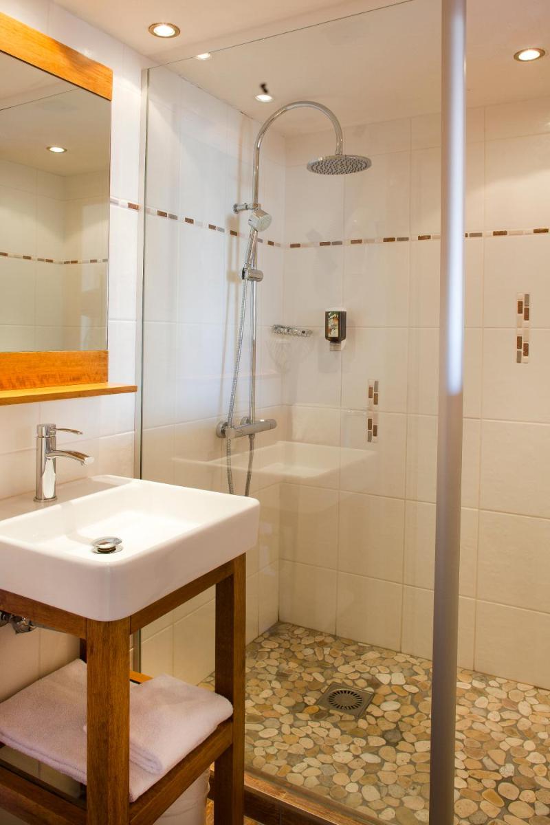 une salle de bain avec un lavabo et une douche dans l'établissement Beaulieu, à La Clusaz