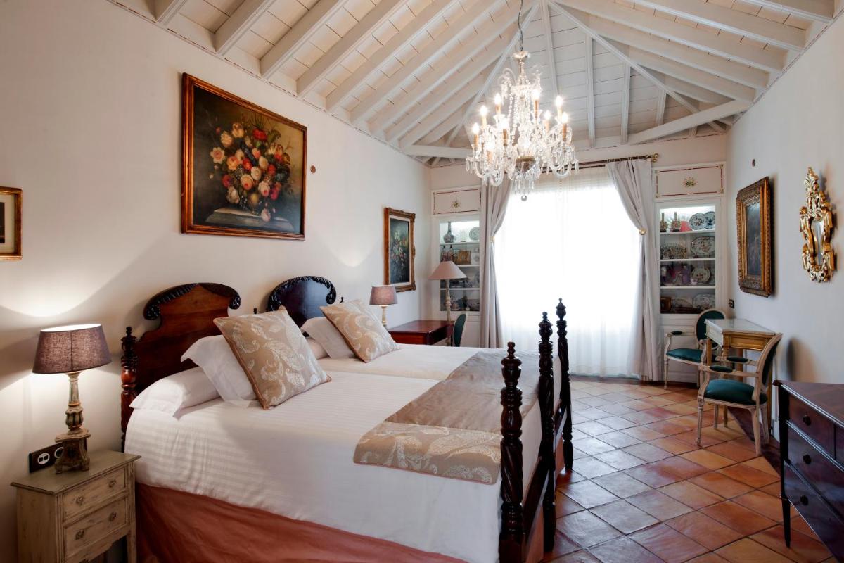 Un dormitorio con una cama grande y una lámpara de araña. en Hotel Hacienda de Abajo-Adults Only-Lujo, en Tazacorte