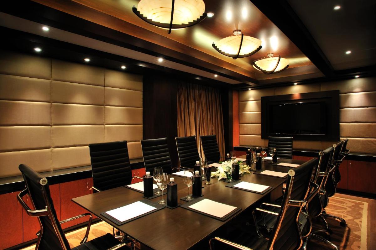 a conference room with a long table and chairs at Taj Club House in Chennai