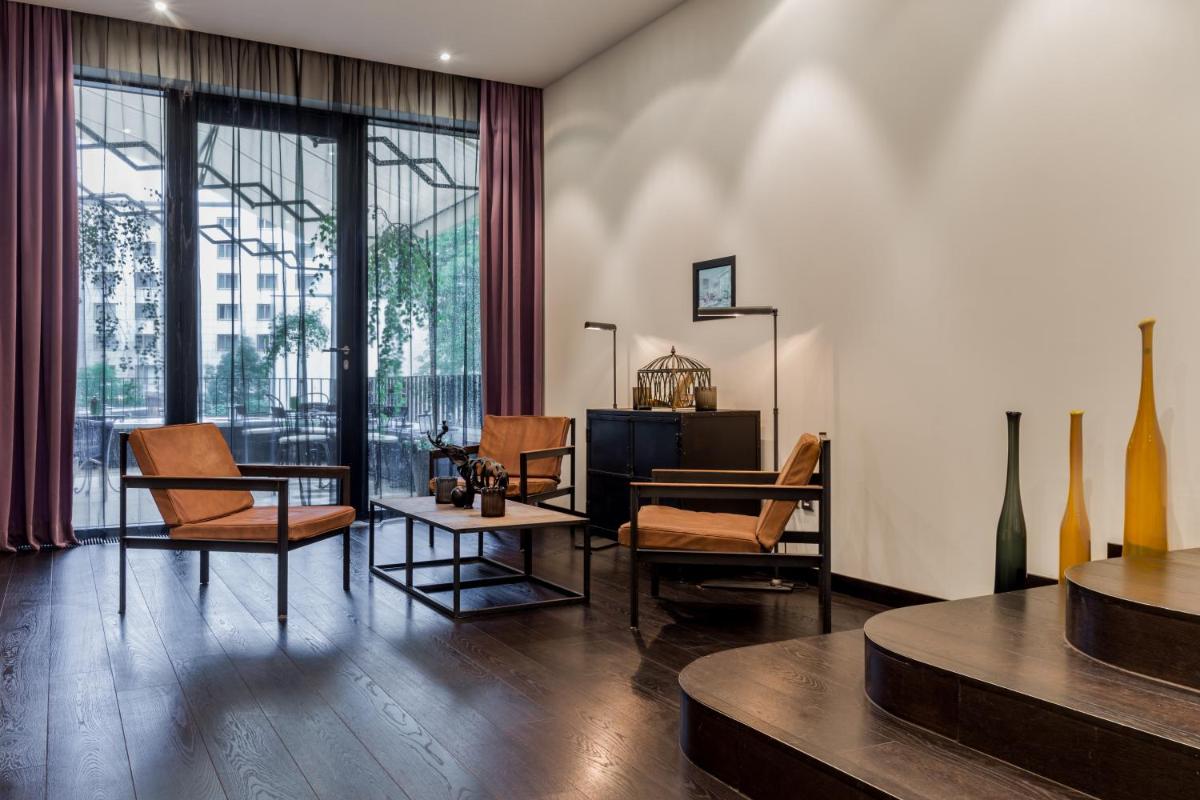 ein Wohnzimmer mit Stühlen und einem Tisch und einem Fernseher in der Unterkunft Hotel Zoo Berlin in Berlin ein Wohnzimmer mit Stühlen und einem Tisch und einem Fernseher in der Unterkunft Hotel Zoo Berlin in Berlin