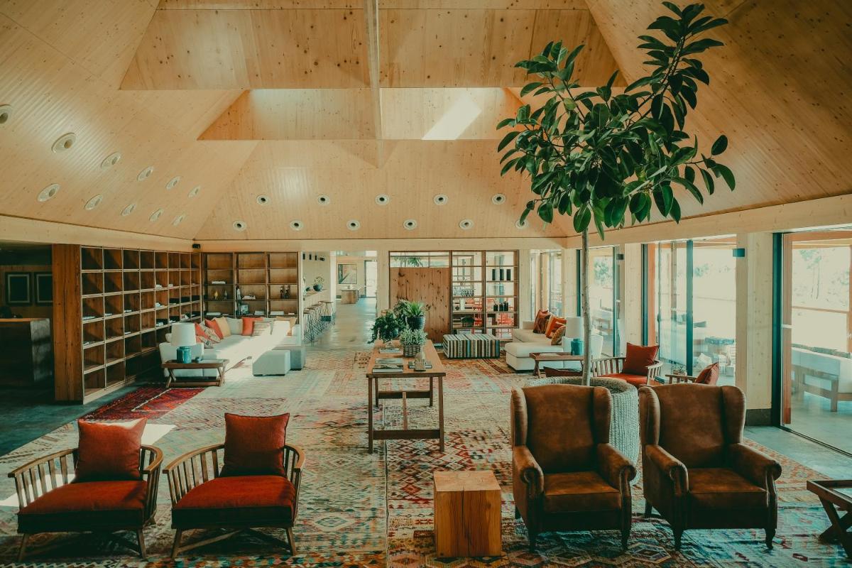 um grande saguão com sofás e cadeiras em uma biblioteca em FeelViana Sport Hotel em Viana do Castelo