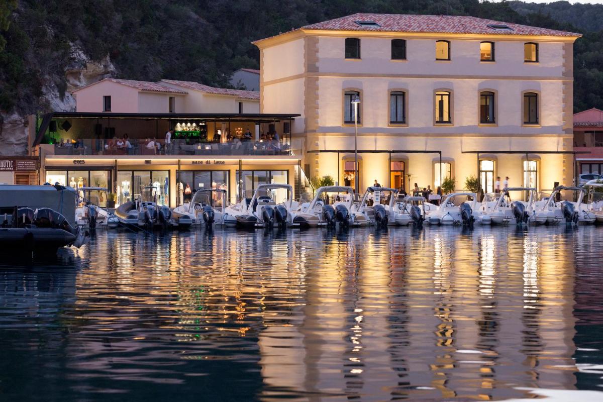 un grand bâtiment à côté d'un plan d'eau dans l'établissement Hotel Centre Nautique, à Bonifacio