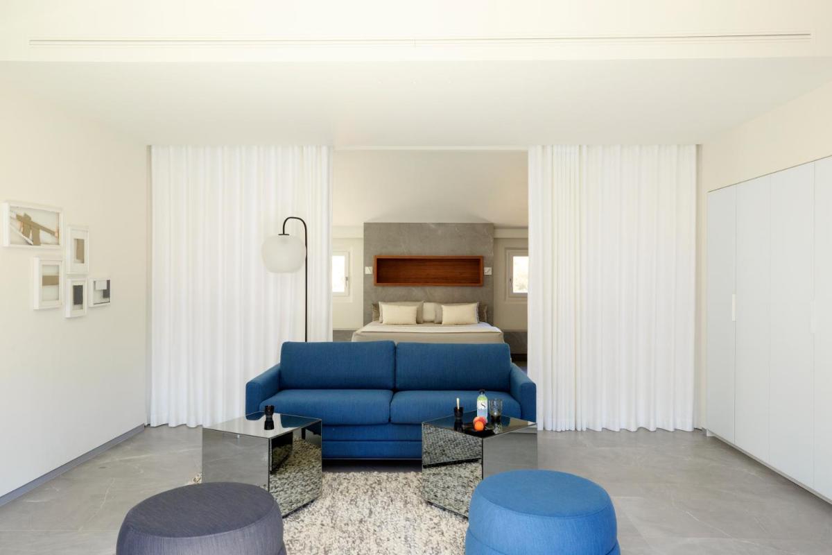 - un salon avec un canapé bleu et un lit dans l'établissement Hotel Centre Nautique, à Bonifacio