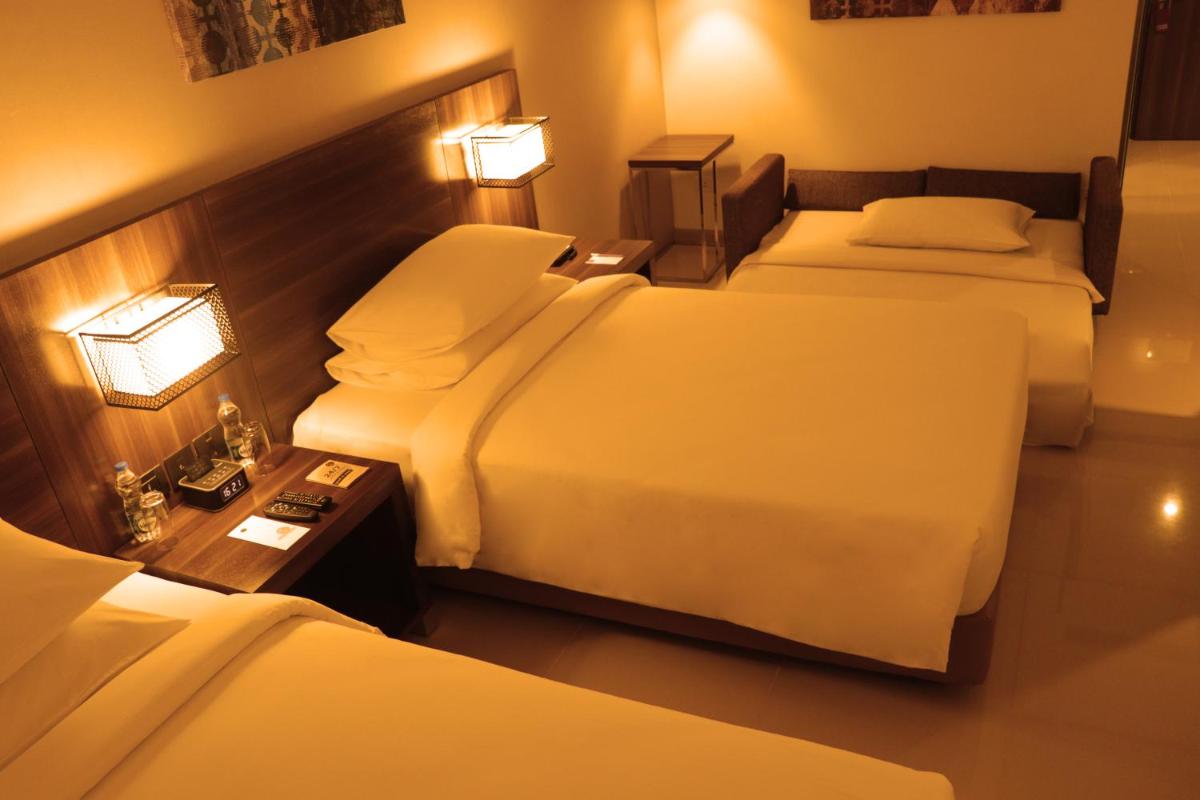 a hotel room with two beds and a table at The Residency Towers, Rameswaram in Rāmeswaram