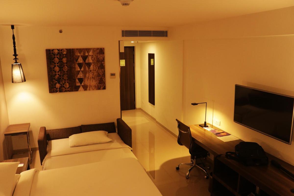 a hotel room with a bed and a flat screen tv at The Residency Towers, Rameswaram in Rāmeswaram