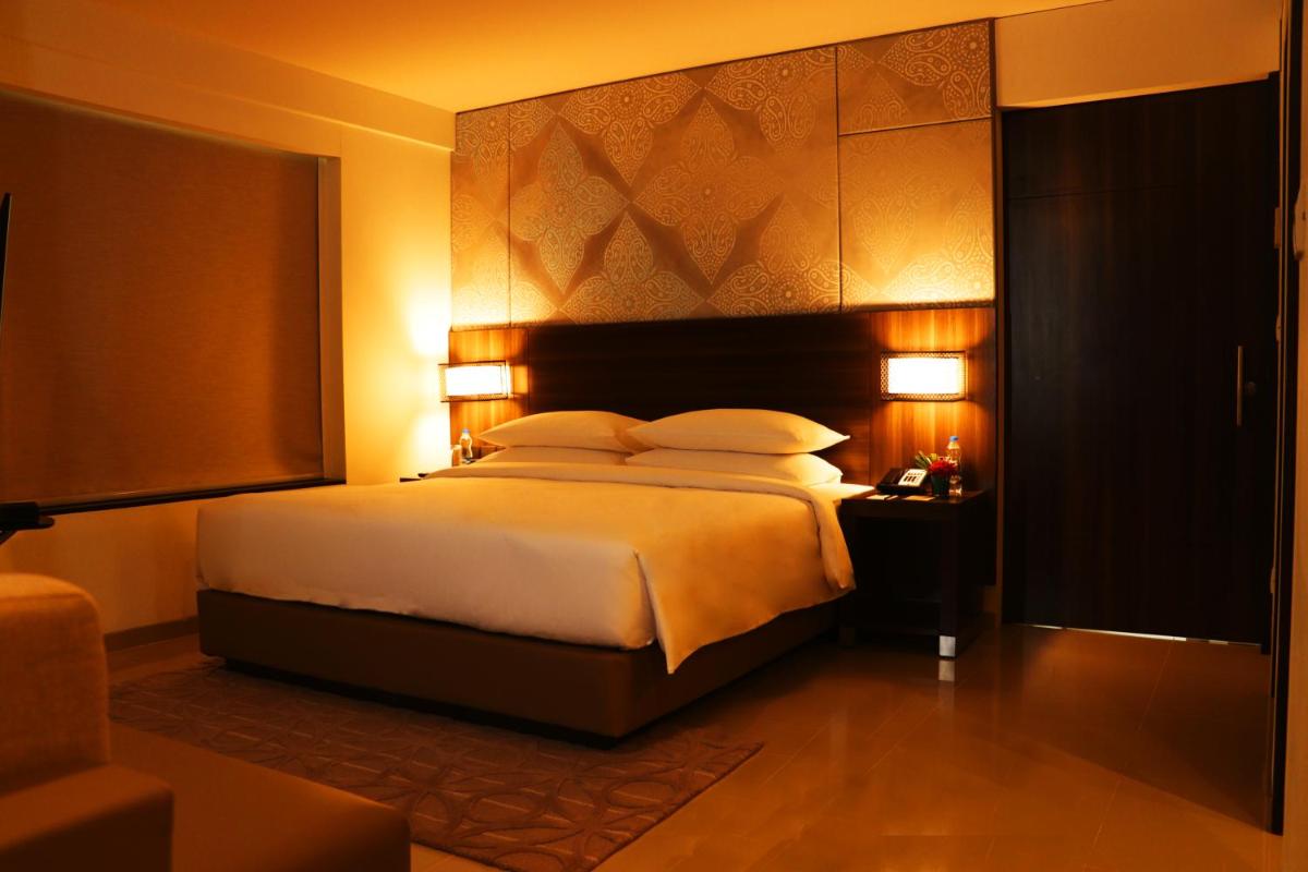a bedroom with a large bed and two lamps at The Residency Towers, Rameswaram in Rāmeswaram