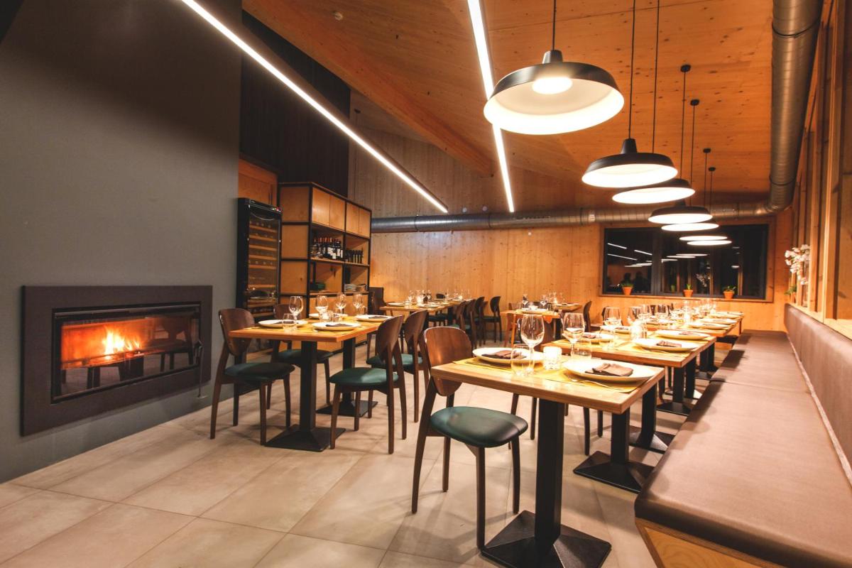 uma sala de jantar com mesas e cadeiras e uma lareira em Bukubaki Eco Surf em Ferrel