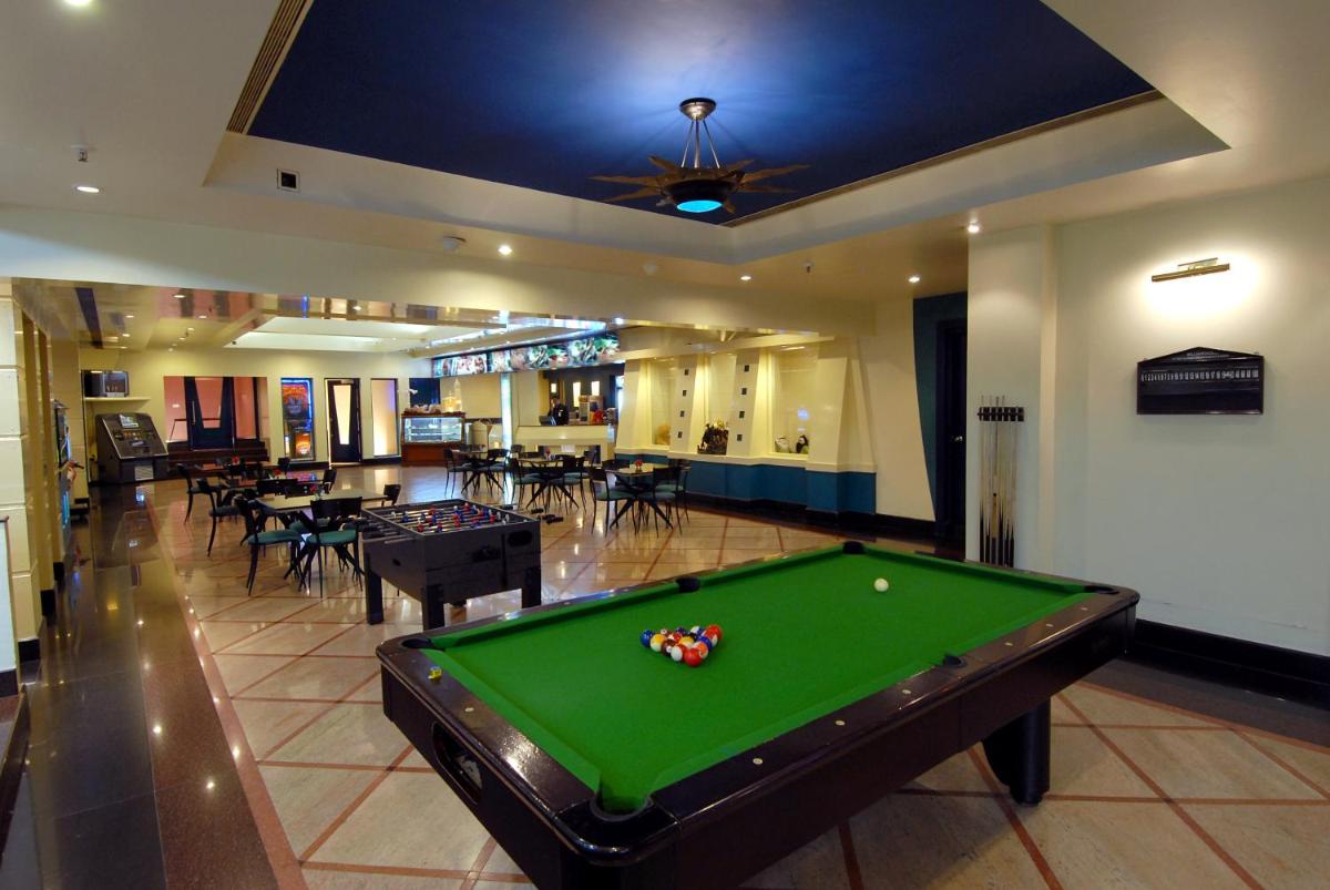 a pool table in a room with tables and chairs at Jaypee Palace Hotel in Agra