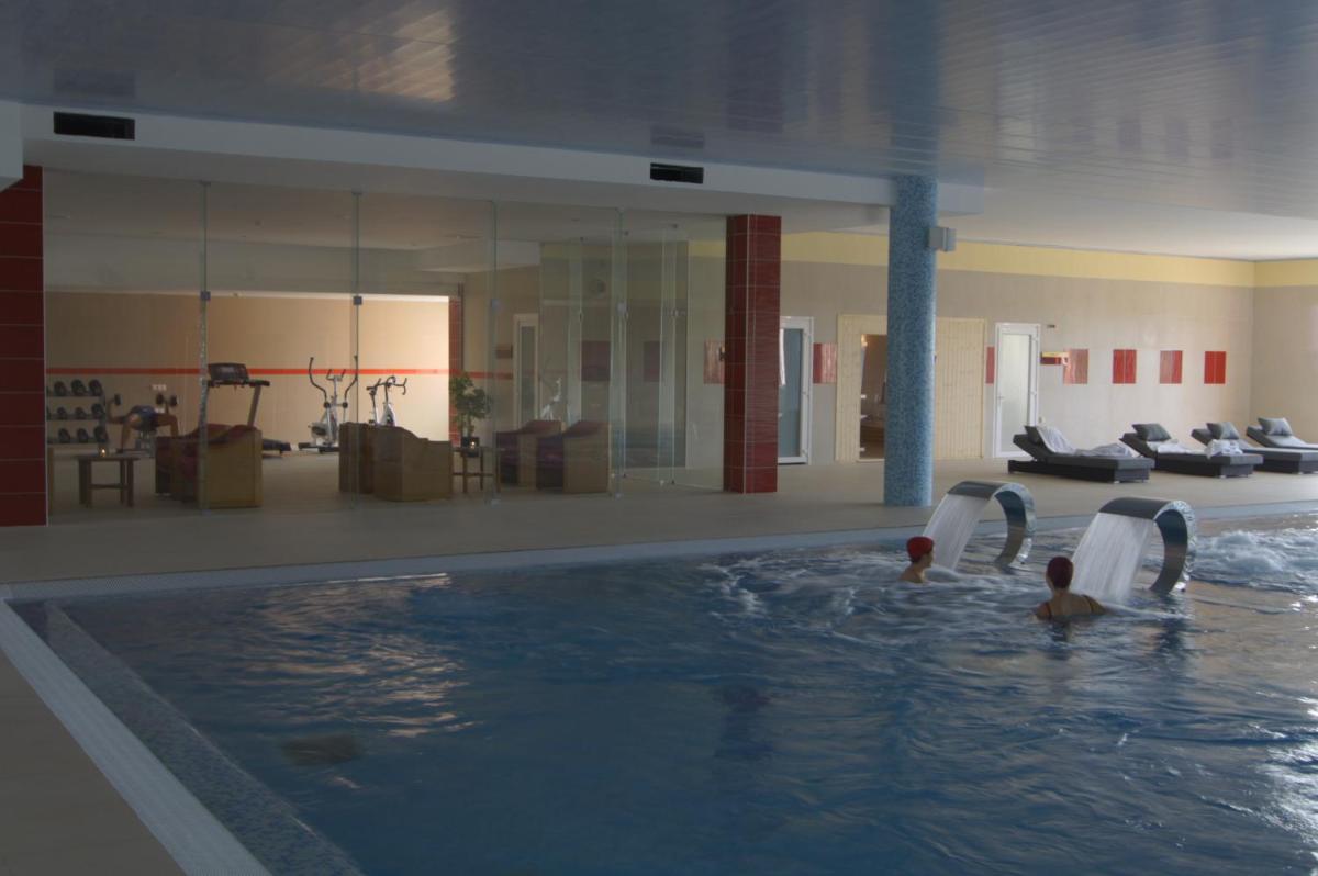 duas pessoas em uma piscina em um prédio em Palace Hotel & Spa Termas de São Tiago em Penamacor