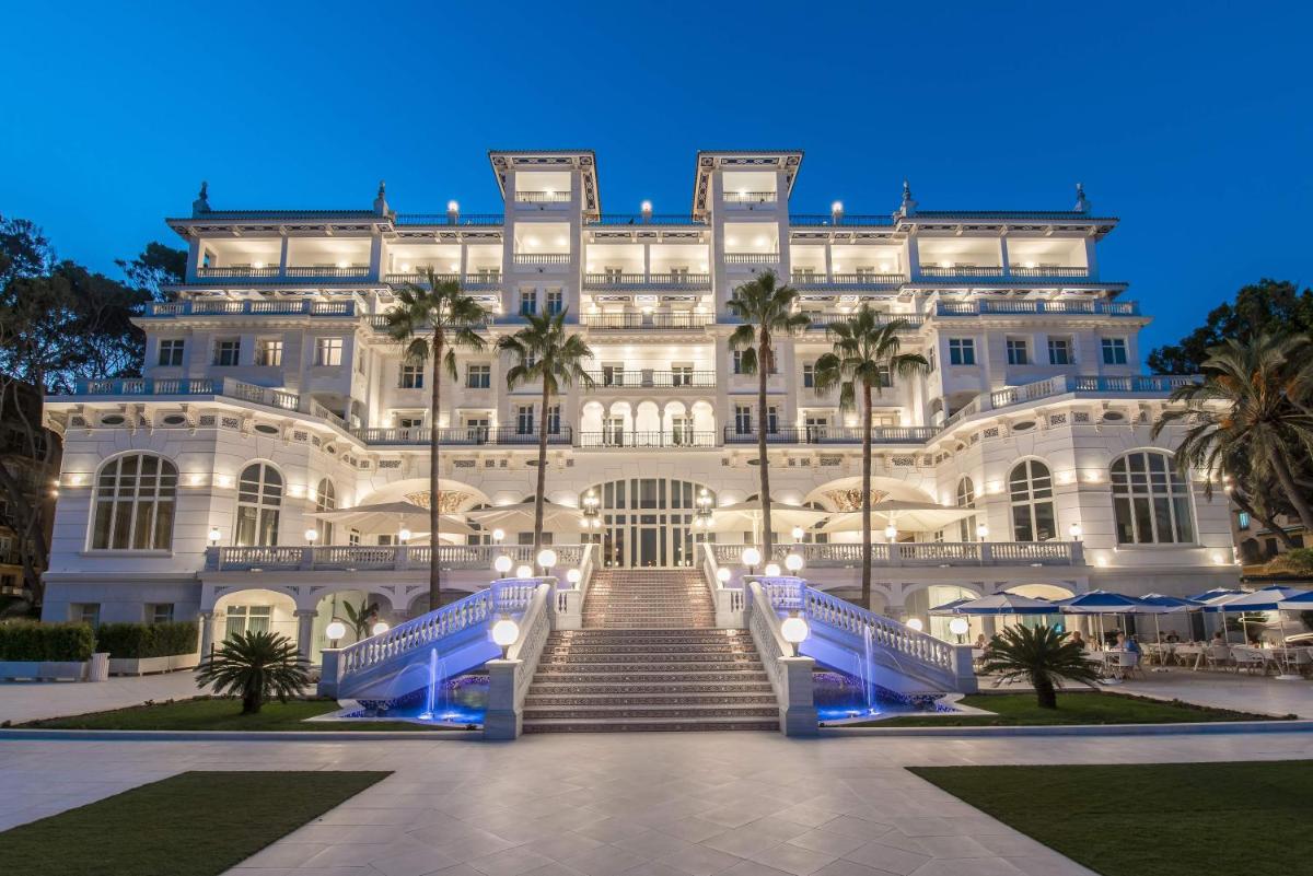 Un gran edificio blanco con escaleras al frente. en Gran Hotel Miramar GL, en Málaga