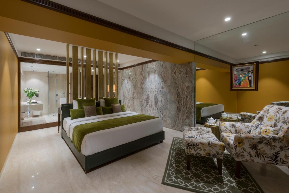 a bedroom with a bed and a living room at Hotel Lakend in Udaipur