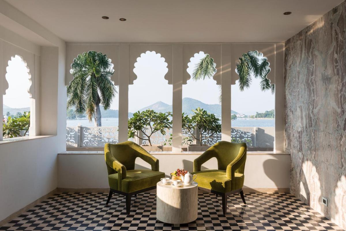 two chairs and a table in a room with windows at Hotel Lakend in Udaipur