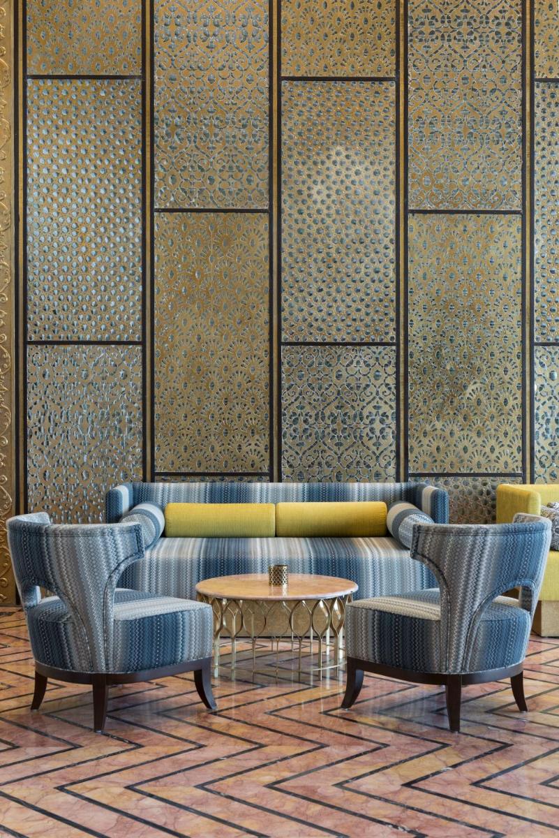 a lobby with a couch and two chairs and a table at Hotel Lakend in Udaipur