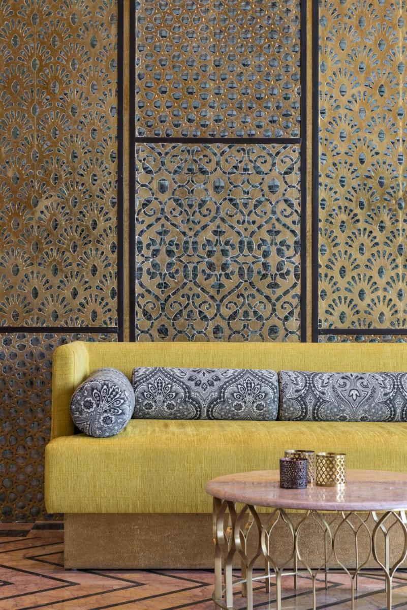 a yellow couch in a room with a table at Hotel Lakend in Udaipur