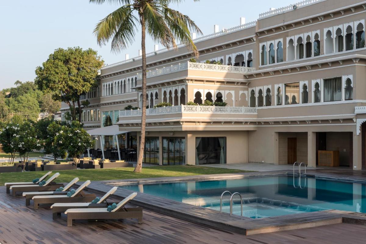 a building with a swimming pool in front of a building at Hotel Lakend in Udaipur