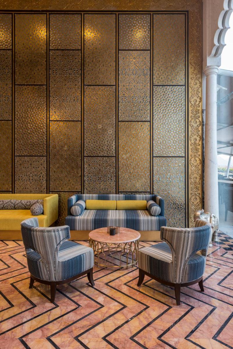 a lobby with couches and a table and chairs at Hotel Lakend in Udaipur