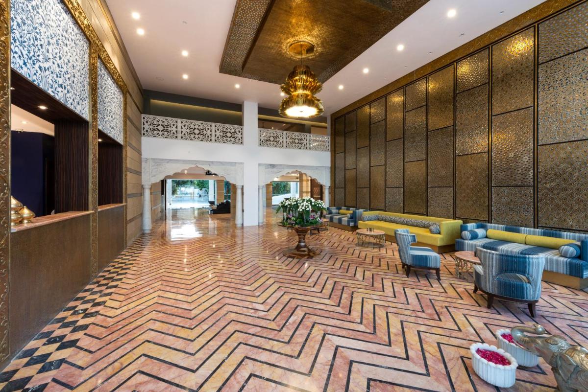 a lobby with couches and chairs in a building at Hotel Lakend in Udaipur