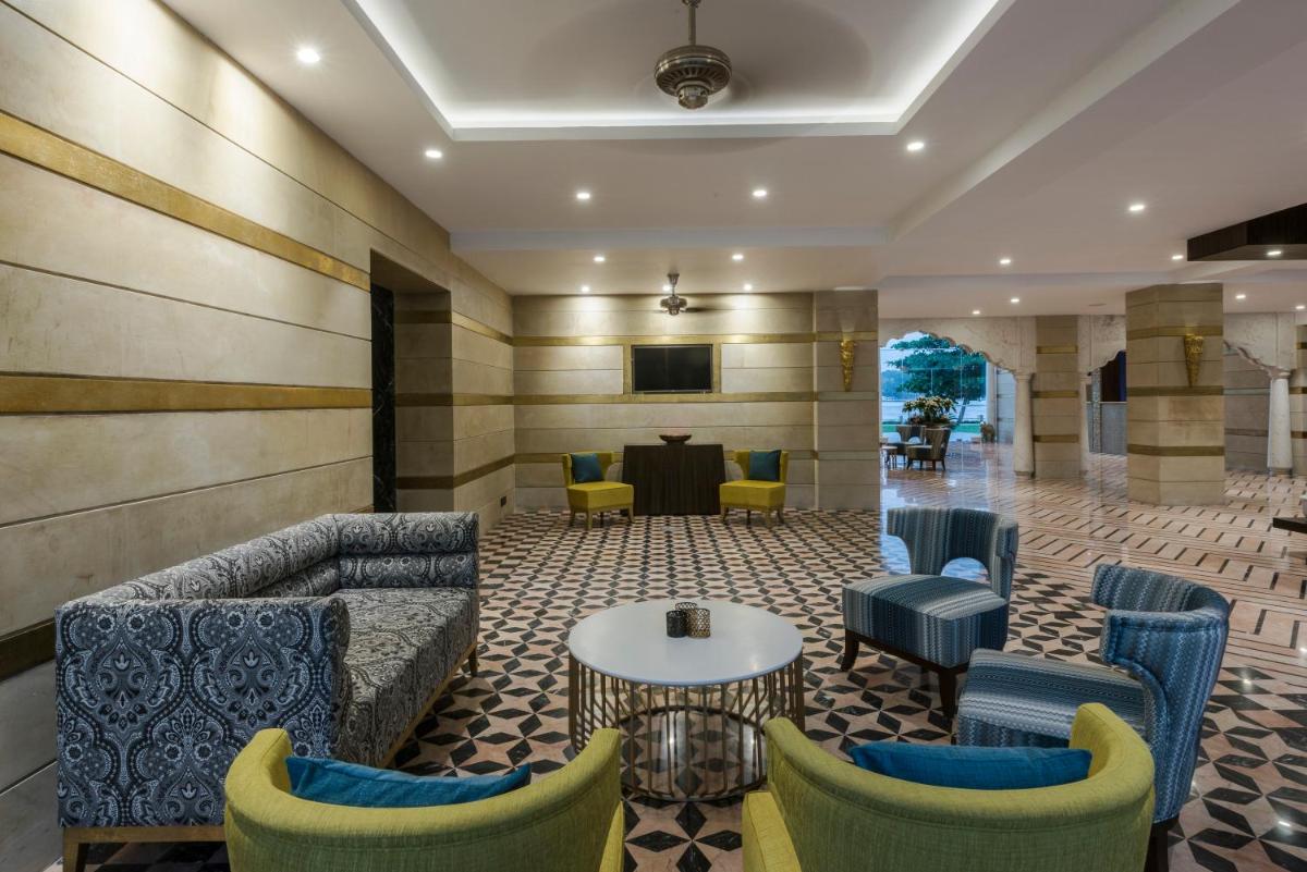 a lobby with couches and a table and chairs at Hotel Lakend in Udaipur