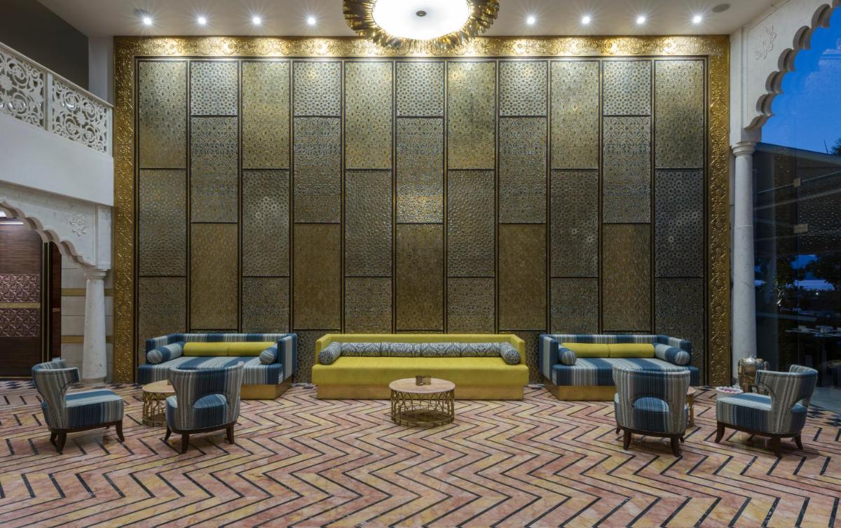 a lobby with couches and tables and a wall at Hotel Lakend in Udaipur