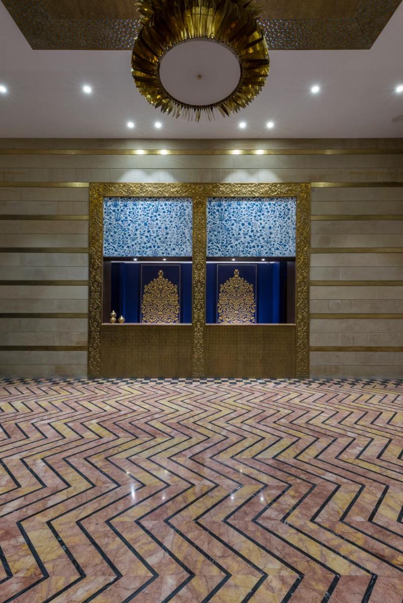 a ballroom with a zigzag floor and windows at Hotel Lakend in Udaipur