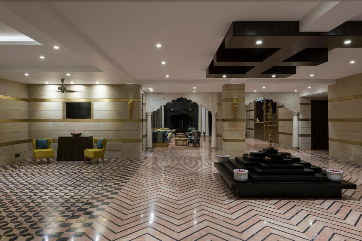 a lobby with a table and chairs in a building at Hotel Lakend in Udaipur