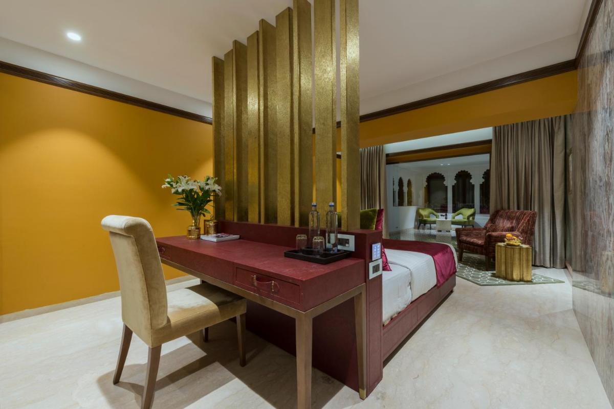 a bedroom with a bed and a desk in a room at Hotel Lakend in Udaipur