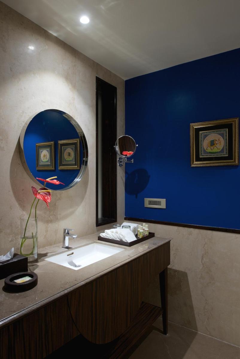 a bathroom with a sink and a blue wall at Hotel Lakend in Udaipur