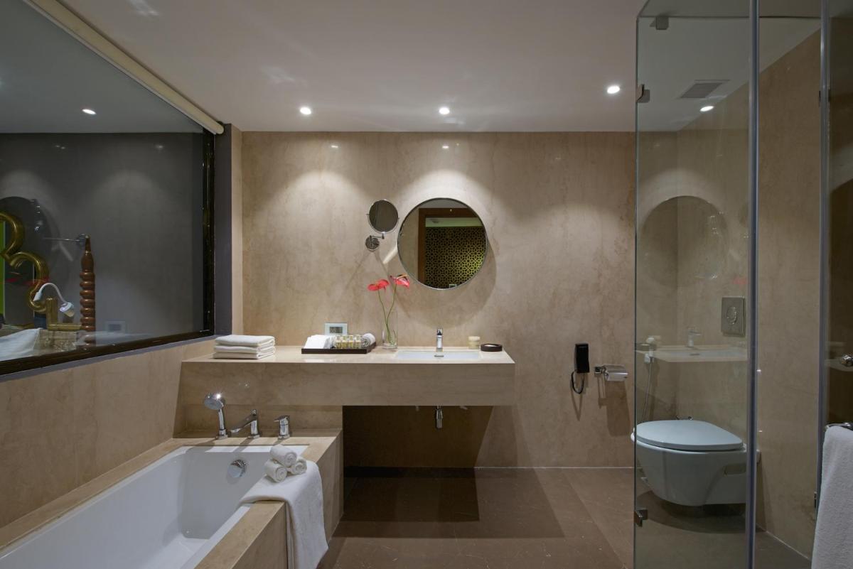 a bathroom with a tub and a sink and a shower at Hotel Lakend in Udaipur