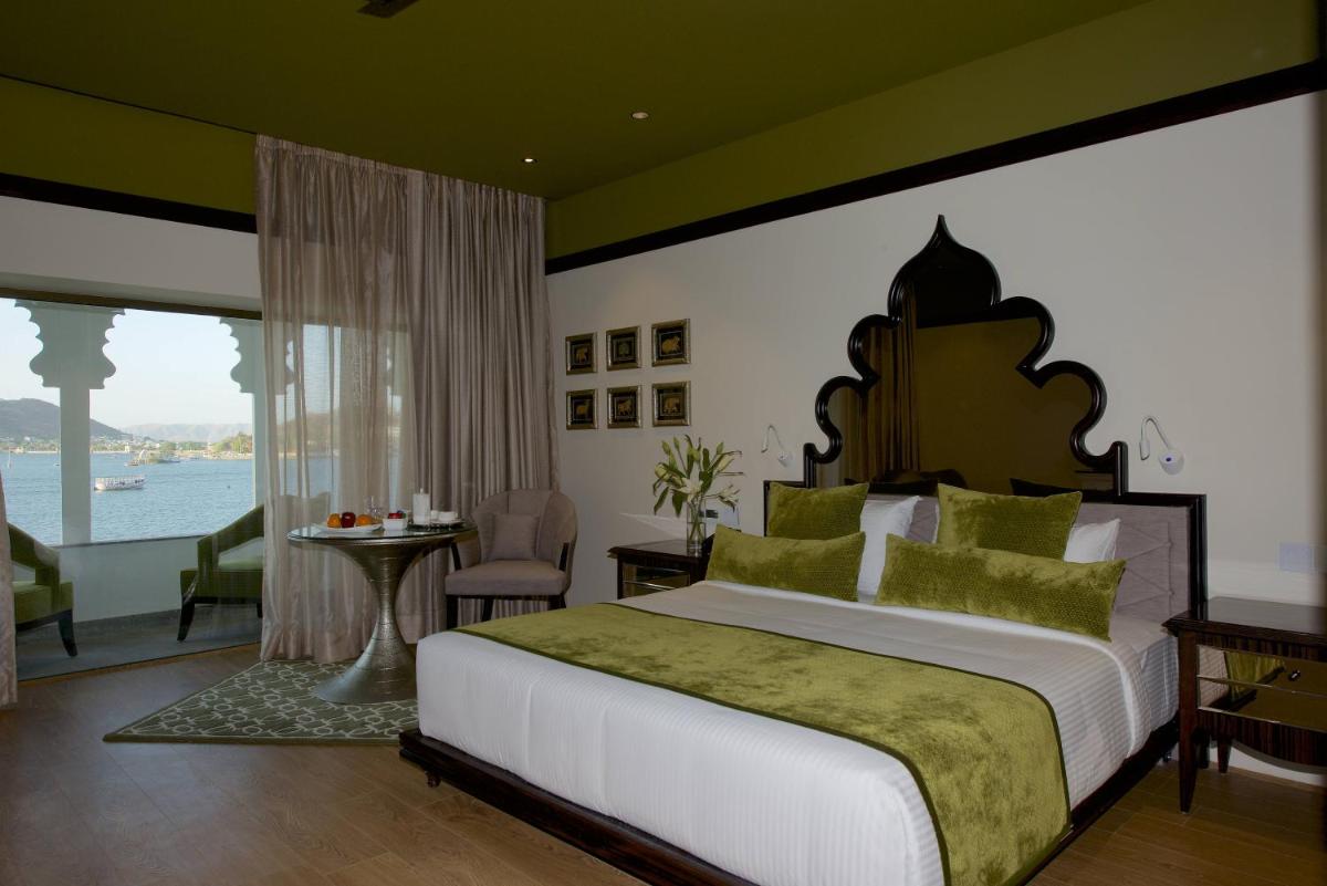 a bedroom with a large bed and a large window at Hotel Lakend in Udaipur