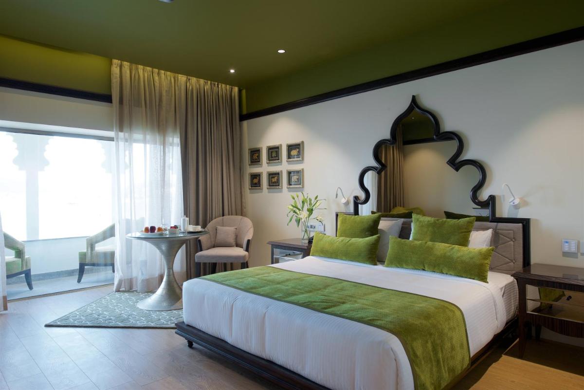 a bedroom with a large bed with a green wall at Hotel Lakend in Udaipur