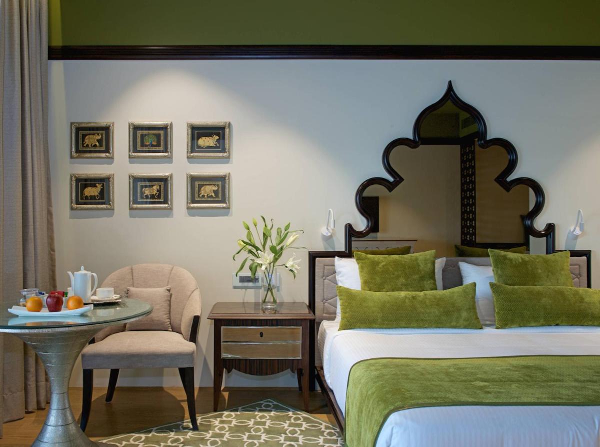 a bedroom with two beds and a table and a chair at Hotel Lakend in Udaipur