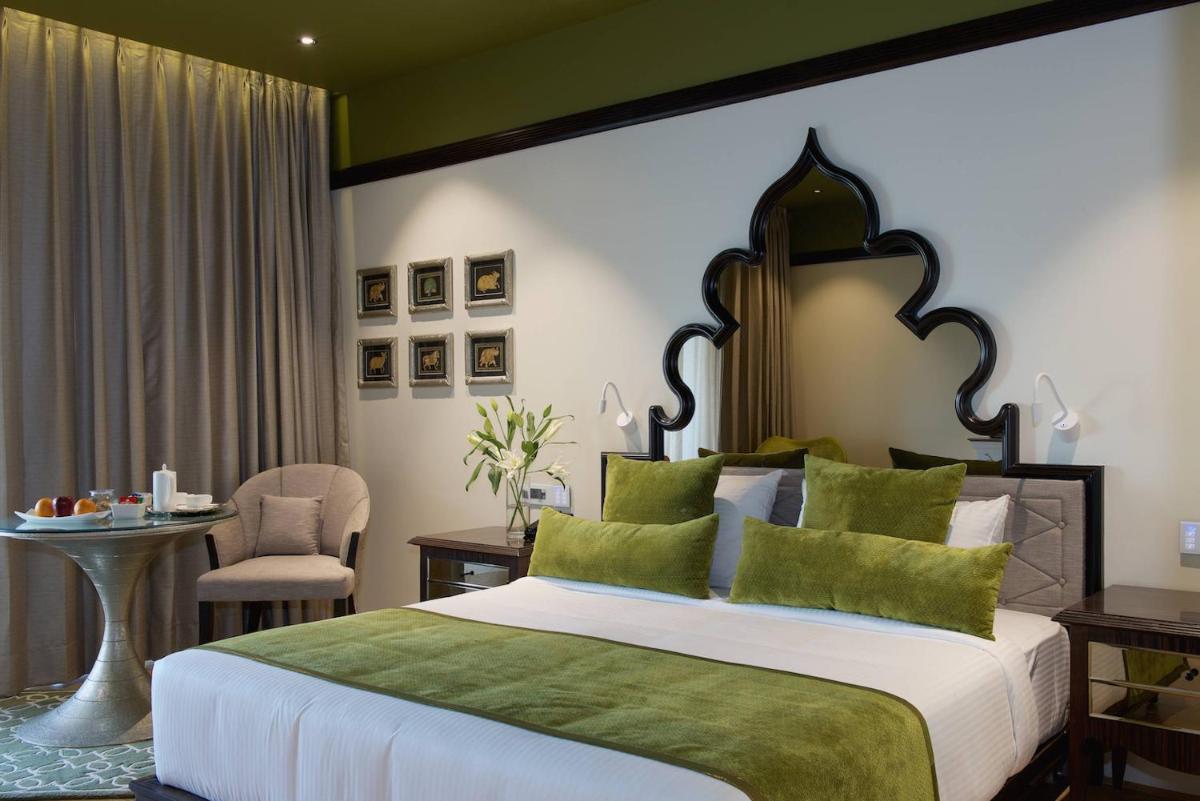 a bedroom with a large bed and a table at Hotel Lakend in Udaipur