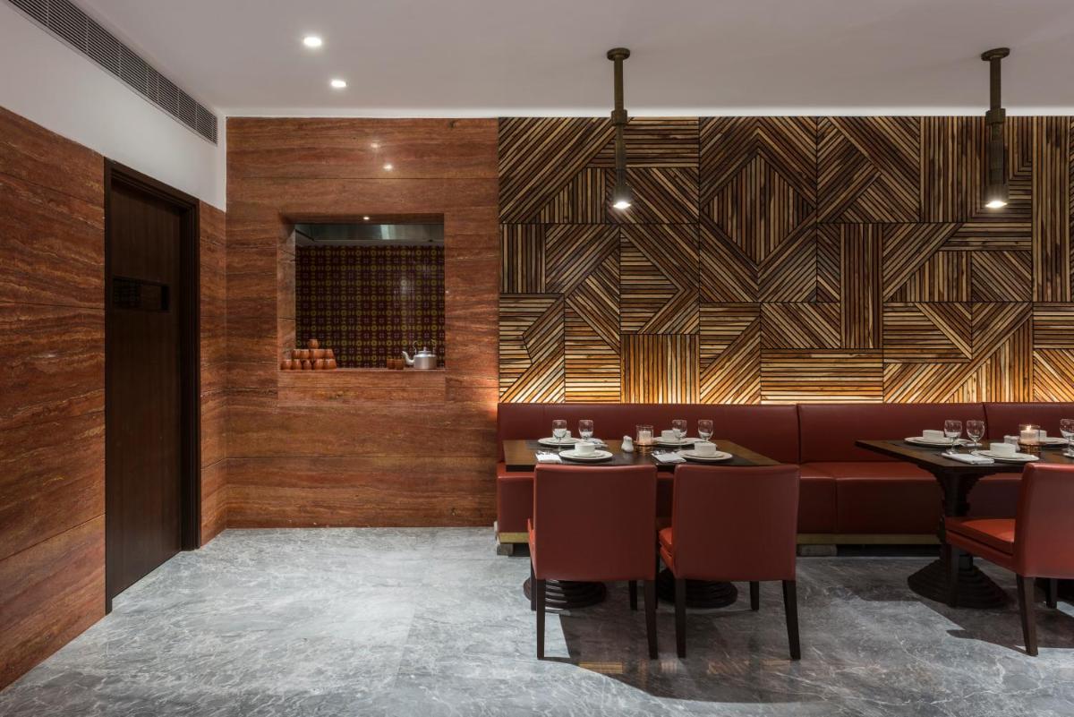 a restaurant with tables and chairs and a wooden wall at Hotel Lakend in Udaipur