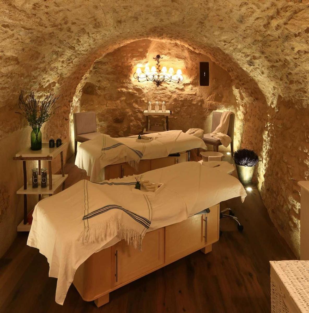 - une salle de massage avec 2 lits dans un mur en pierre dans l'établissement Hotel Crillon le Brave, à Crillon-le-Brave