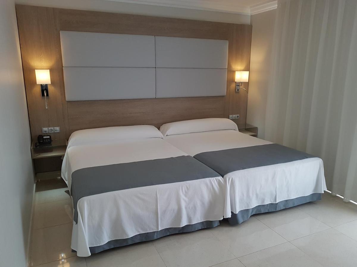 1 cama grande en un dormitorio con 2 luces encendidas en Mediterraneo Bay Hotel & Resort, en Roquetas de Mar