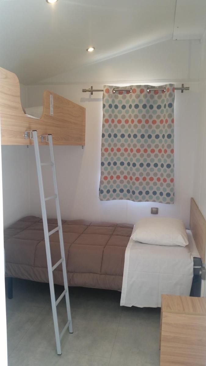 Un ou plusieurs lits dans un hébergement de l'établissement Camping La Pinède